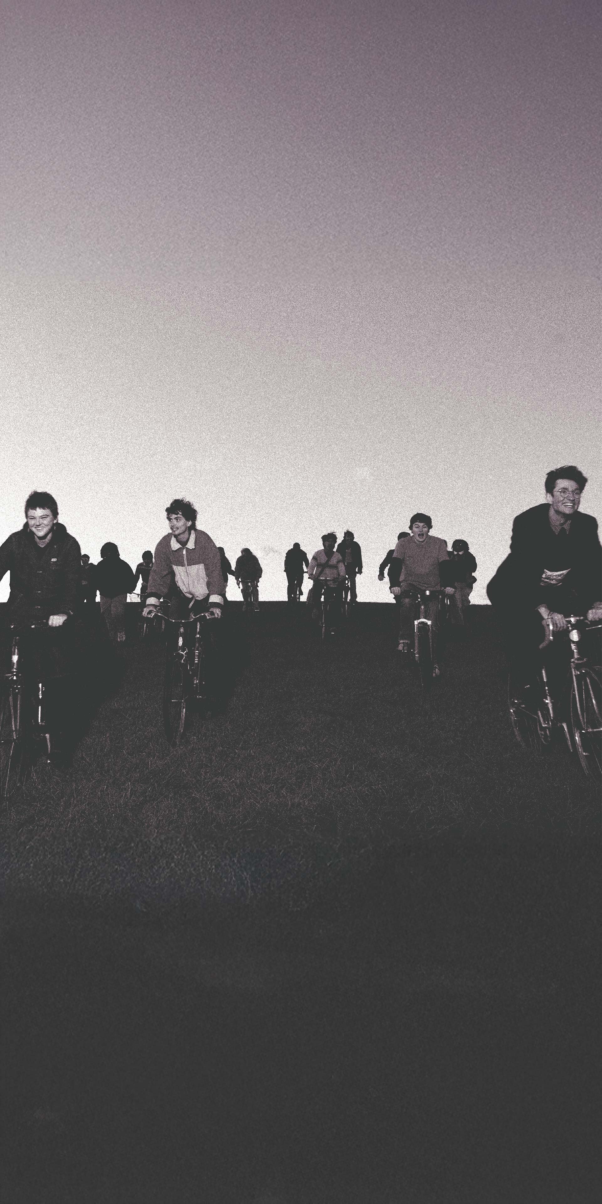 Black and white photo of the band riding bikes